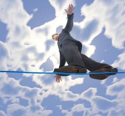 Young businessman walking on line in the air. Holding balance. Low angle view