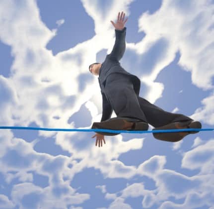 Young businessman walking on line in the air. Holding balance. Low angle view